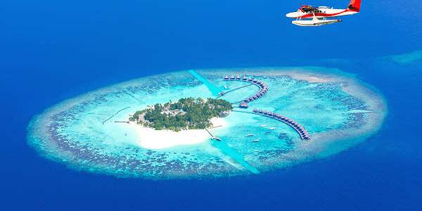Bild eines traumhaften Atolls der Malediven mit türkisfarbenem Meer, weißen Sandstränden und Palmen