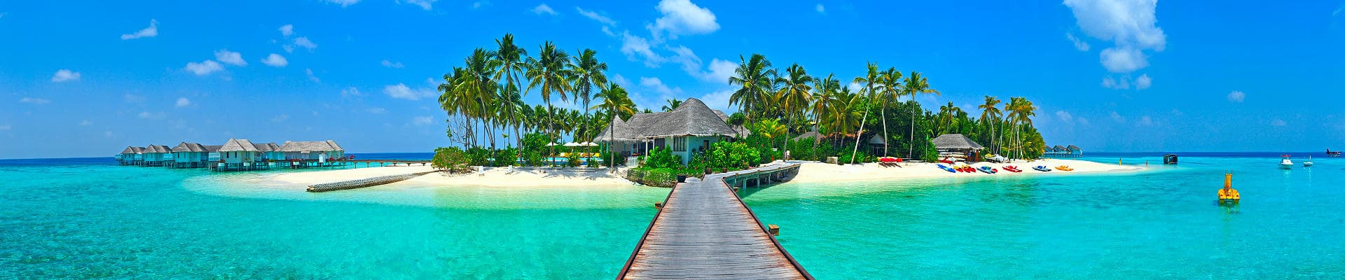 Ein malerisches Reiseziel mit Holzsteg, tropischer Insel, weißem Sandstrand, Palmen und türkisblauem Meer