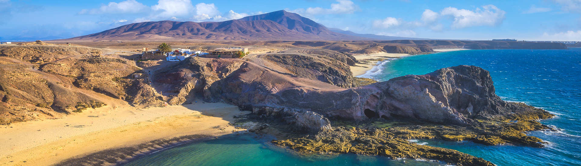 Blick auf den Papagayo-Strand auf Lanzarote, umgeben von klarem Wasser und goldgelbem Sand