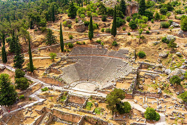 Blick auf das antike Theater von Delphi in Griechenland, umgeben von Bergen und grüner Landschaft.