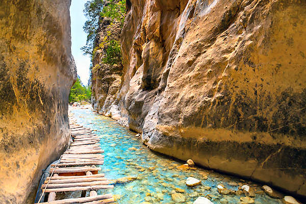 Wanderer in der Samaria-Schlucht auf Kreta, umgeben von steilen Felswänden