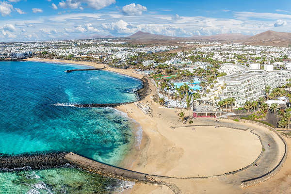 Küstenblick auf Costa Teguise während eines Lanzarote Urlaubs mit ruhigen Stränden und Wassersportmöglichkeiten.