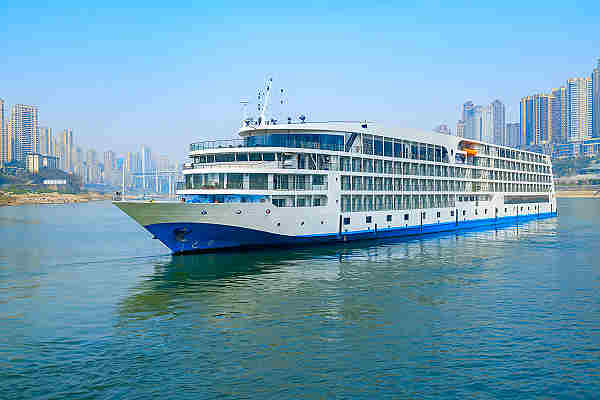Ein Kreuzfahrtschiff kreuzt den mächtigen Yangtze-Fluss bei sonnigem Wetter
