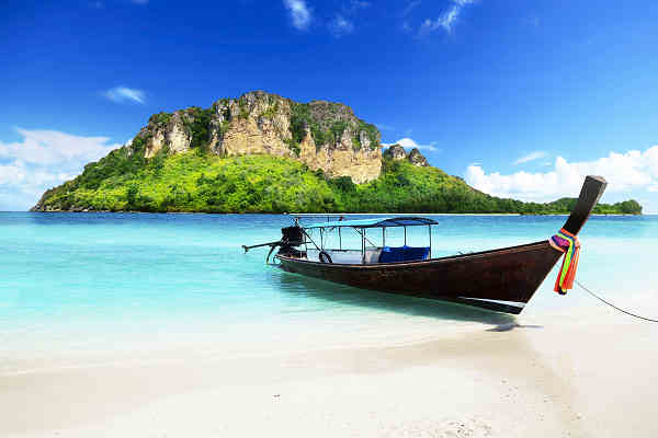 Bild eines traditionellen Longtail-Boot in kristallklarem Wasser vor der Küste Phukets