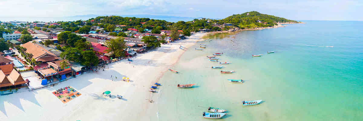 Bild vom Haad Rin Beach auf Koh Phangan: Ein lebhafter Strand, umgeben von natürlicher Schönheit