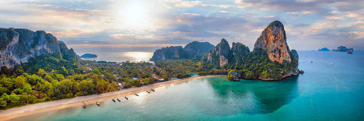 Bild des atemberaubenden Railay Beach in Krabi, Thailand, umgeben von beeindruckenden Kalksteinfelsen und türkisblauem Wasser
