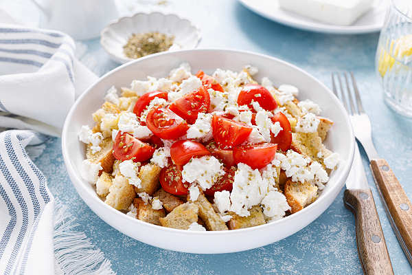 Dakos – Traditionelles kretisches Gericht aus frischen Zutaten Traditioneller Dakos-Salat aus Kreta mit Tomaten, Olivenöl und Gerstenzwieback