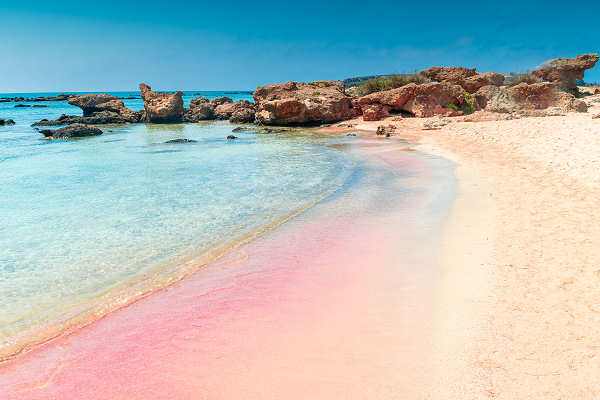 Strand von Elafonissi auf Kreta in Griechenland mit türkisfarbenem Wasser und weißem Sand