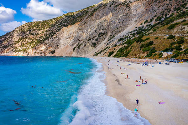 Panoramablick auf den Myrtos Beach auf Kefalonia, Griechenland, mit türkisblauem Wasser und beeindruckenden Felsklippen.