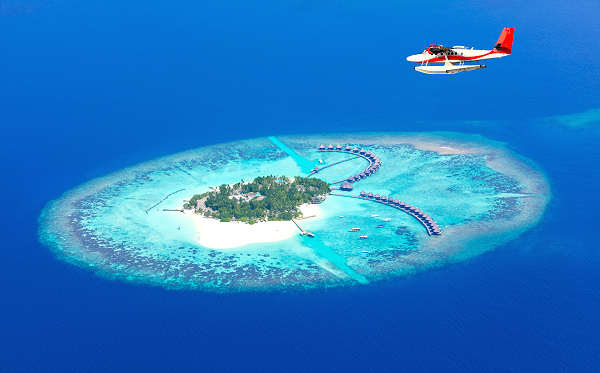 Bild eines traumhaften Atolls der Malediven mit türkisfarbenem Meer, weißen Sandstränden und Palmen