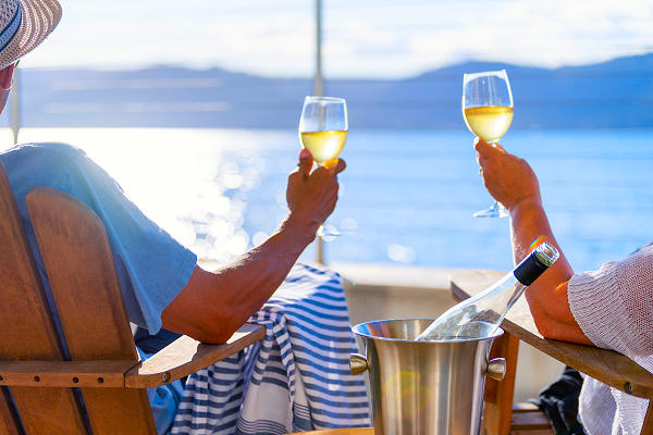 Luxuskreuzfahrt genießen – stilvolle Auszeit mit AsiaGo auf hoher See Zwei Personen mit Weißweingläsern auf Deck einer Luxuskreuzfahrt – stilvolle Entspannung mit AsiaGo im Mittelmeer oder der Karibik