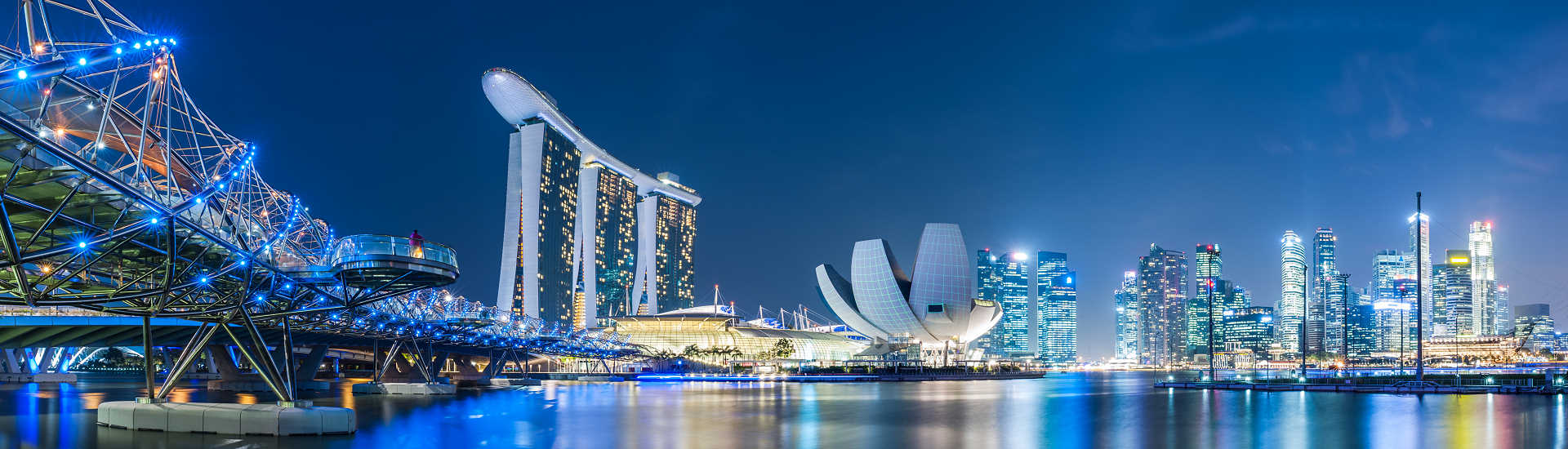 Singapur Skyline bei Nacht – Luxusreisen mit AsiaGo Beleuchtete Skyline von Singapur mit Marina Bay Sands und Helix Bridge – exklusives Reiseziel für Luxusurlaub mit AsiaGo